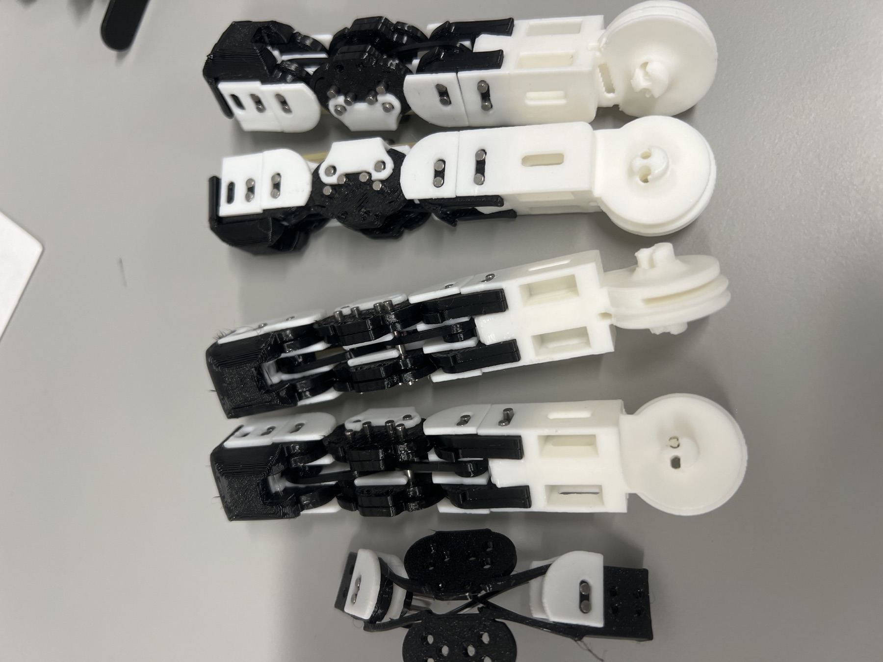 Several assembled CRAFT compliant finger modules laid out on a workbench